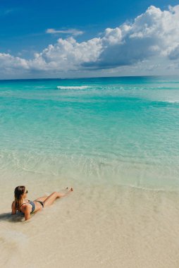 Cancun, Meksika 'da kumsalda parlak mayo giymiş esmer bir kız.