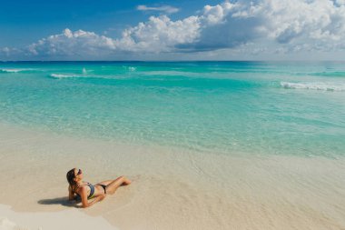 Cancun, Meksika 'da kumsalda parlak mayo giymiş esmer bir kız.