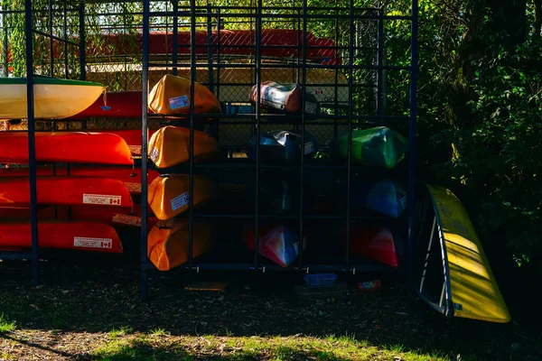 Multi-colored canoes and kayaks on racks texture of colored kayaks on a sunny day. — 스톡 사진