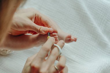 Çocuk tırnağını kesen makas tutan ebeveyn.