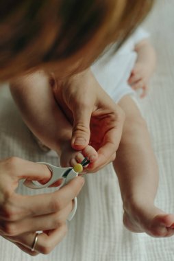 Çocuk tırnağını kesen makas tutan ebeveyn.