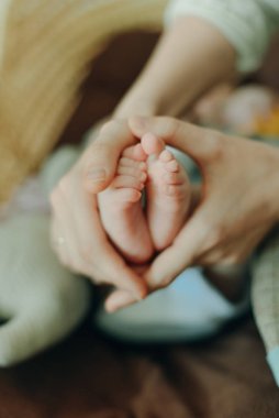 Bebek ayakları annenin ellerinde. Anne ve çocuğu. Mutlu aile kavramı. Anneliğin güzel kavramsal görüntüsü