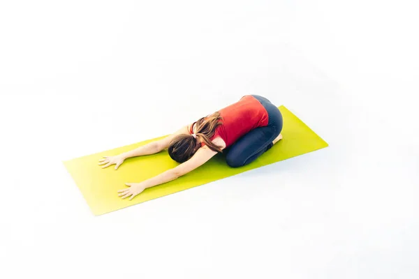 Retrato de vista lateral de una hermosa joven haciendo ejercicio de yoga o pilates sobre fondo blanco — Foto de Stock