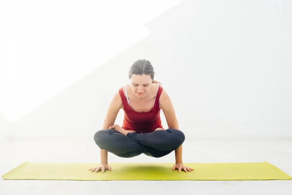 Retrato de vista lateral de una hermosa joven haciendo ejercicio de yoga o pilates sobre fondo blanco —  Fotos de Stock