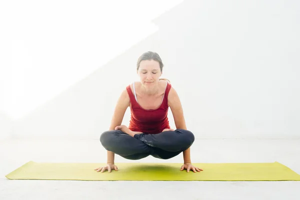 Retrato de vista lateral de una hermosa joven haciendo ejercicio de yoga o pilates sobre fondo blanco —  Fotos de Stock