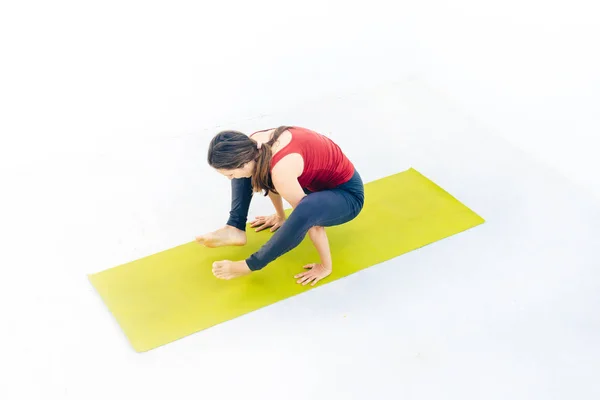 Retrato de vista lateral de una hermosa joven haciendo ejercicio de yoga o pilates sobre fondo blanco —  Fotos de Stock