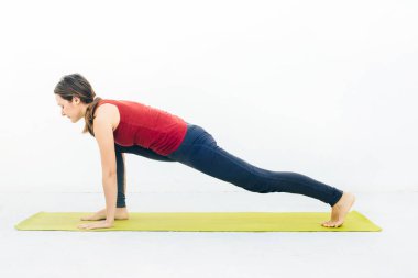 Güzel bir genç kadının, yoga yaparken ya da beyaz arka plan üzerinde pilates yaparken yan görünümü.