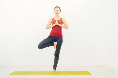 Güzel bir genç kadının, yoga yaparken ya da beyaz arka plan üzerinde pilates yaparken yan görünümü.