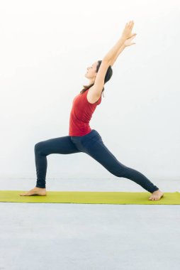 Güzel bir genç kadının, yoga yaparken ya da beyaz arka plan üzerinde pilates yaparken yan görünümü.