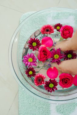 Kireç ve tropikal çiçeklerle dolu tabakta ayak banyosu, kaplıca pedikür tedavisi, üst manzara.