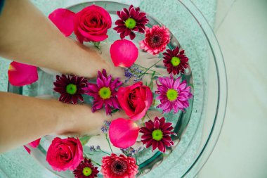 Kireç ve tropikal çiçeklerle dolu tabakta ayak banyosu, kaplıca pedikür tedavisi, üst manzara.