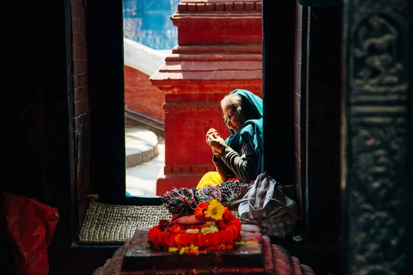 Katmandú, Nepal - Marzo 2019 mujer se sienta en el territorio en el templo de Pashupatinath . —  Fotos de Stock