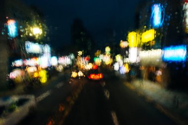 Arabanın içinde. Arkaplan için yağmurlu bir günde soyut bulanıklık. Yağmur damlaları, arabanın ön camına su damlaları.