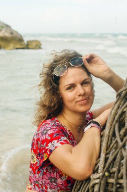 Okyanusun arka planında parlak elbiseli sarışın.