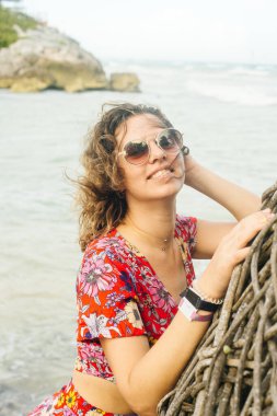 Okyanusun arka planında parlak elbiseli sarışın.