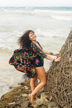 Okyanusun arka planında parlak elbiseli esmer.