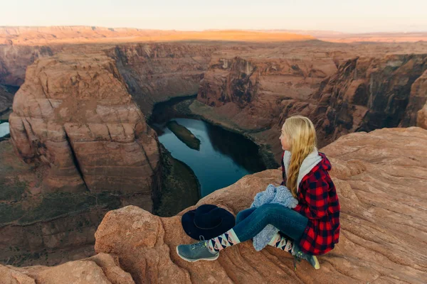 Chica rubia sentada Horseshoe Bend en Glen Canyon National Recreation Área al amanecer — Foto de Stock