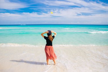Okyanusun arka planında şapkalı bir kız. Güzel kız denize bakıyor.. 