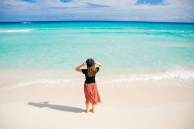Okyanusun arka planında şapkalı bir kız. Güzel kız denize bakıyor.. 