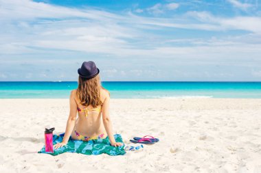 Cennet yaz tatili mutluluğu kaygısız mutlu kadın kumsalda oturup tropik plaj varış yerinin tadını çıkarıyor.. 