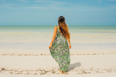 Güzel bir kız sırtı Meksika sahilinde duruyor.