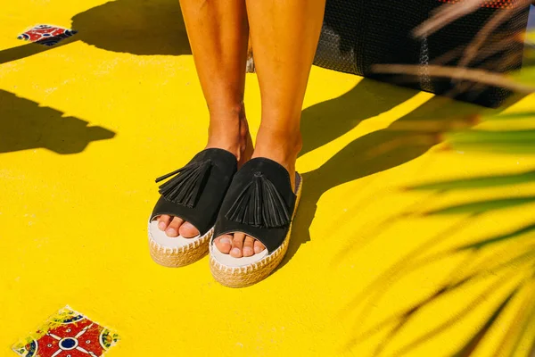 Black shoes on the yellow floor in summertime — Stock Photo, Image