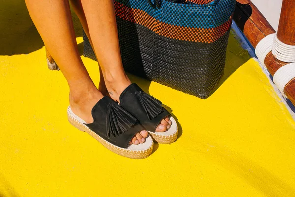 Zapatos negros en el suelo amarillo en verano —  Fotos de Stock