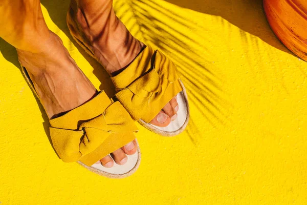 Legs of a girl in yellow shoes on a yellow floor. — Stock Photo, Image