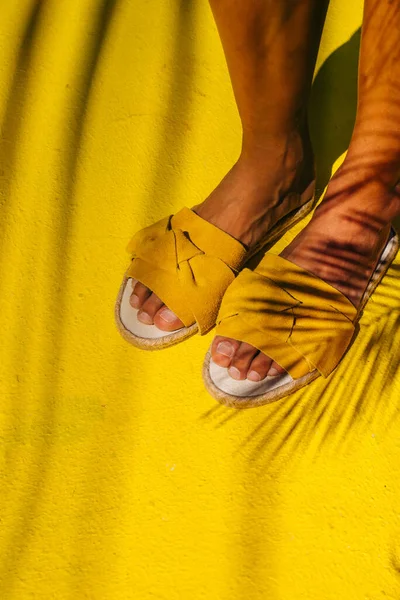 Ben av en flicka i gula skor på ett gult golv. — Stockfoto