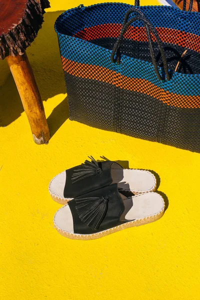 Black shoes on the yellow floor in summertime — Stock Photo, Image