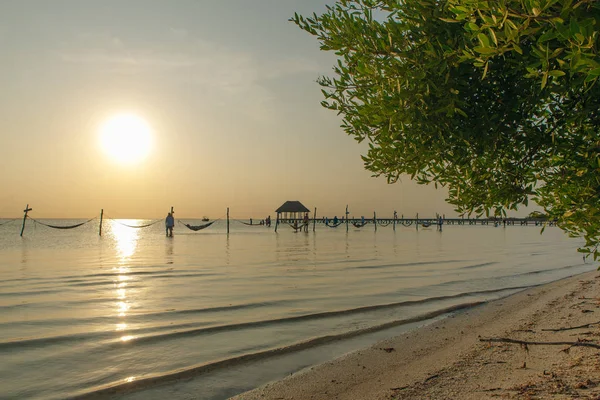 Entspannung in einer Hängematte über dem Wasser bei Sonnenuntergang, isla holbox, Mexico — Stockfoto