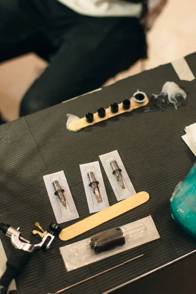 Tattoo artist workplace with machine and bottles with black tattoo ink — Stock Photo, Image