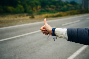 Yolcu olarak araba istemek için otostop çeken bir kadın..