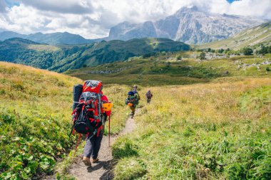 Dağlarda büyük sırt çantalarıyla grup yürüyüşü. Rusya.