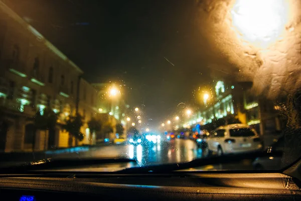 車の中だ背景は雨の日にぼけている 雨が降り 車のフロントガラスに水が落ちる — ストック写真