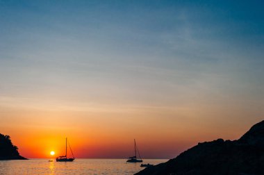 Gün batımında bir yatın silueti Phuket Adası Yanui sahilinde, Tayland.