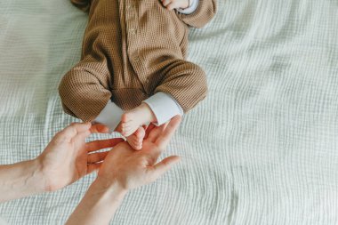 Bacakları yeni doğmuş bebek ve annesinin kolları..