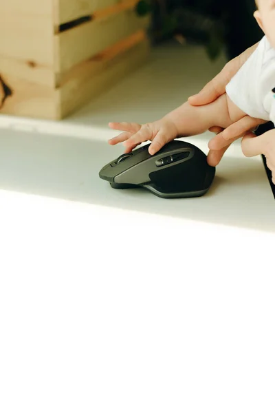 Бездротова комп'ютерна миша і маленька рука дитини — стокове фото