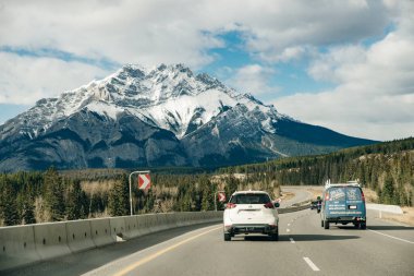 Kanada Kayalık Dağları 'ndan geçen manzaralı bir yol, kayalık dağlarla çevrili. Banff Ulusal Parkı, Alberta, Canad 'da çekilmiş..
