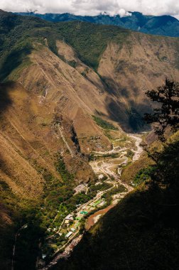Kayıp İnka şehri Machu Picchu, Cucco yakınlarında. Gri taş inka duvarlar ve dağın önündeki yeşil çimenler..