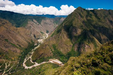 Kayıp İnka şehri Machu Picchu, Cucco yakınlarında. Gri taş inka duvarlar ve dağın önündeki yeşil çimenler..