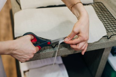 Elin bir parça kağıt tutsun ve makas kullanarak kessin.