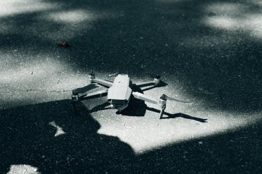 İnsansız hava aracı yerde yatıyor. İHA 'yı yere indiriyorum. Gri helikopter hazır durumda..