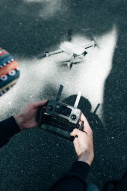 Uzaktan kumanda. Uzaktan kumandalı adam. Adam uzaktan kumandayı elleriyle tutuyor ve insansız hava aracını kontrol ediyor.