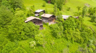 Havadan görünümü, yeşil dağ Alp chalets mavi s altında eğimlidir.