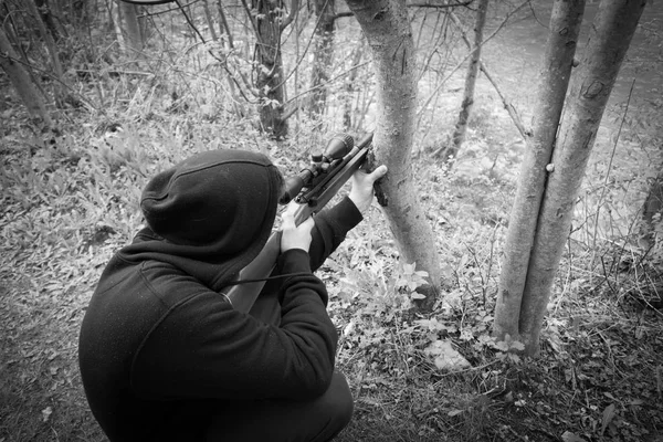 Close-up de homem com chapelaria apontando com rifle sniper — Fotografia de Stock