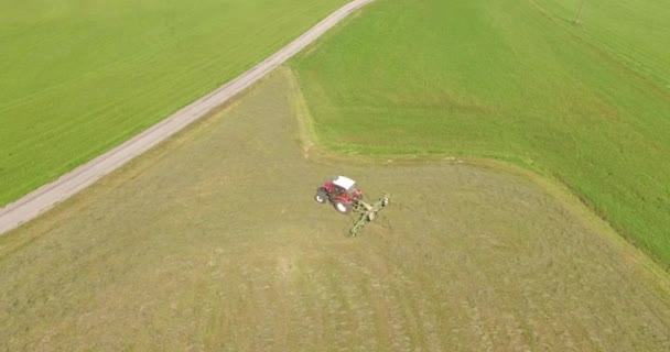 Aeria viewl - farmář soustružení trávy na podpory sušení na seno — Stock video
