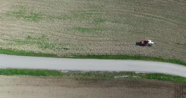 Luchtfoto, trekker en zaaimachine een veld in de zomer, boer in Oostenrijk. — Stockvideo