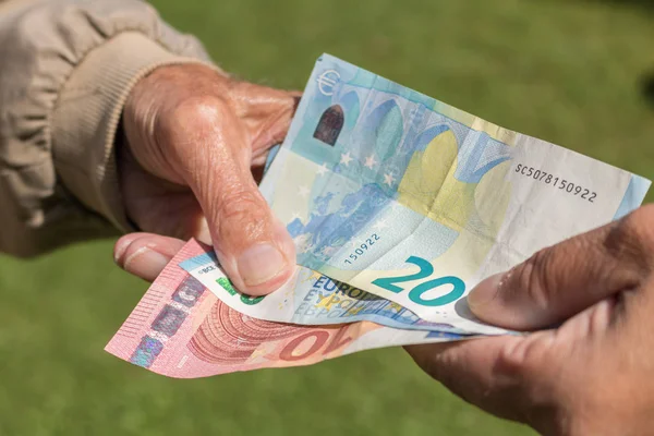 Senior man's hands holding Euro banknote. Struggling pensioners Royalty Free Stock Images