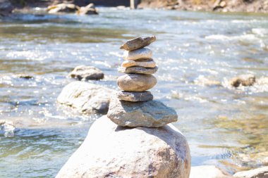 R mavi su dağ Nehri üzerinde dengeli taş piramit. Chi